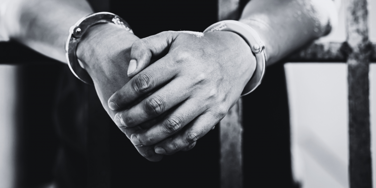 hand cuffed arms of a man to undergo criminal trial