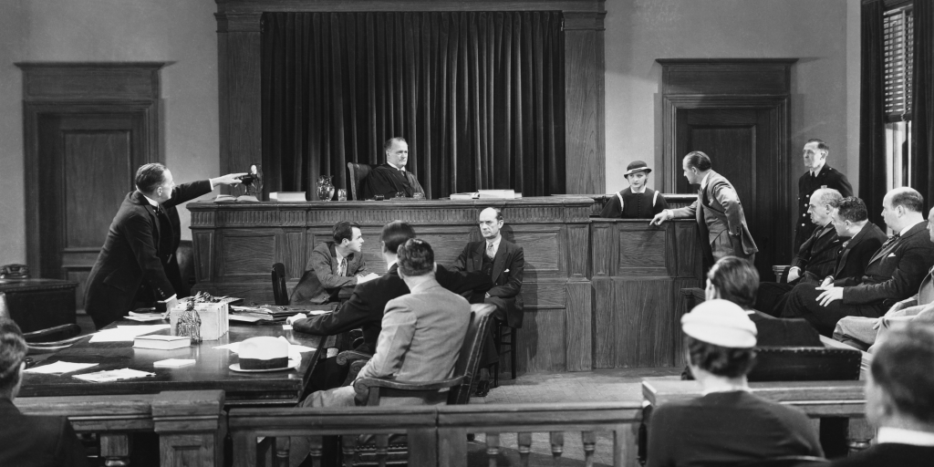 scene in a criminal trial, with a judge. lawyer and other players 