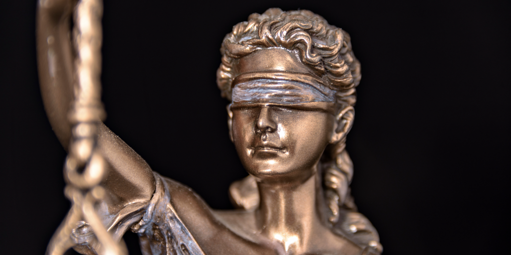 Themis, symbol of justice close up, highlighting her blindfolded eyes.
